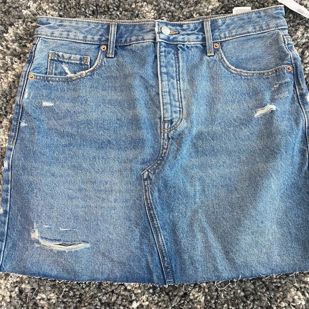 High waisted button fly raw hem jeans skirt.